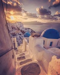 Panoramic view of sea and buildings against sky during sunset