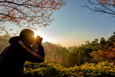 Man in park against sky during sunset