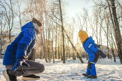 Rear view of man with arms raised in winter