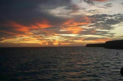 Scenic view of sea against dramatic sky during sunset