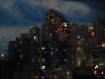 Close-up of illuminated cityscape against sky