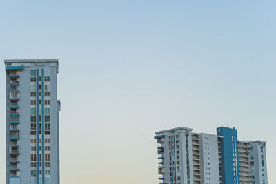 High-rise condominiums against clear blue sky at sunset with copy space