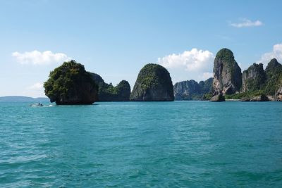 Scenic view of sea and rock formations against blue sky