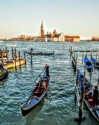 Gondolas in grand canal by san marco campanile against clear sky