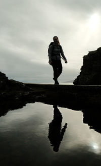 Low angle view of man standing on lake