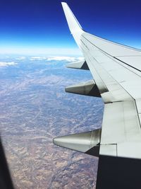 Cropped image of airplane wing over landscape