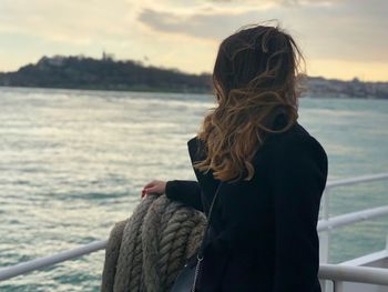 Rear view of woman standing in boat