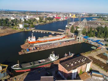 High angle view of city by river and buildings against sky