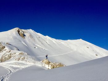 Scenic view of snowcapped mountains against clear blue sky