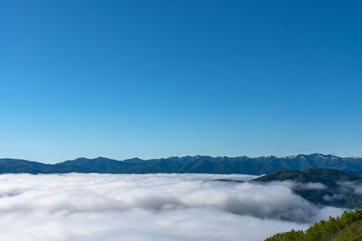 Scenic view of snowcapped mountains against clear blue sky