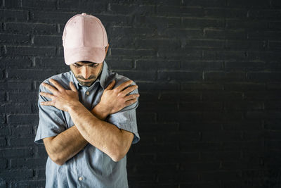 Portrait of man standing against wall