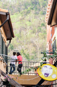 Rear view of people on road against trees