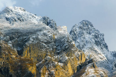 Low angle view of frozen mountain against sky