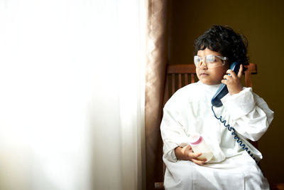 Boy standing against wall at home