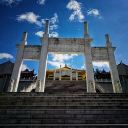 Low angle view of cross against cloudy sky