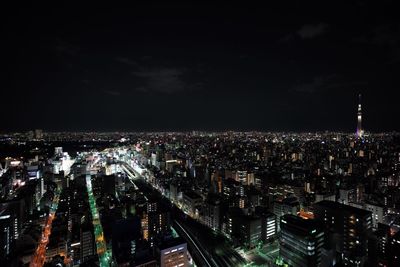 Illuminated cityscape against sky at night