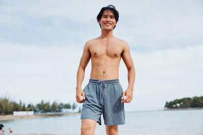 Shirtless man standing against sky