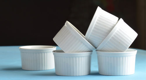 Close-up of white cups on table