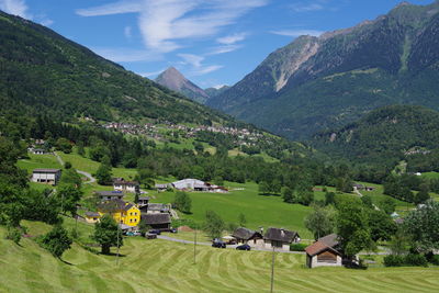 Houses by trees and mountains against sky