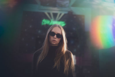 Portrait of young woman in city at night