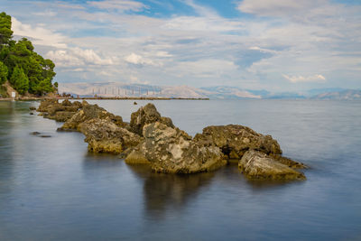 Scenic view of rocks in sea against sky