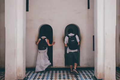 Rear view of woman standing against door