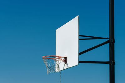 Low angle view of basketball hoop against blue sky