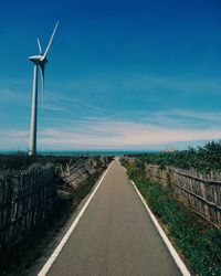 Go to the beach , road amidst landscape against blue sky .