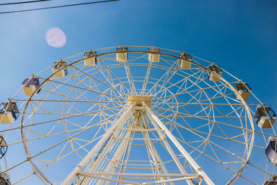 Low angle view of ferris wheel against blue sky