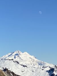 Scenic view of snowcapped mountains against clear blue sky