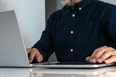 Midsection of man using laptop at office