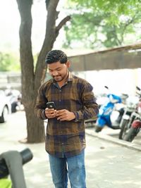 Full length of young man using mobile phone