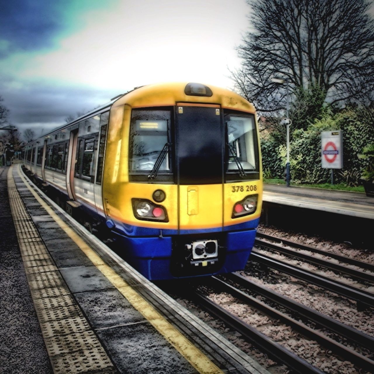 railroad track, rail transportation, transportation, public transportation, railroad station, train - vehicle, railroad station platform, mode of transport, passenger train, train, travel, public transport, railway track, tree, journey, sky, on the move, diminishing perspective, yellow, cable car