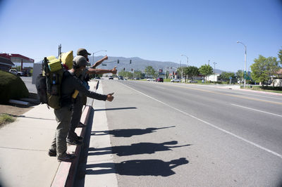 Shadow of woman on road against clear sky