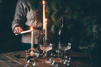 Woman lighting candles for christmas diner.