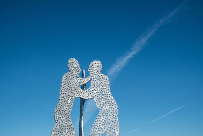 Low angle view of vapor trails in blue sky