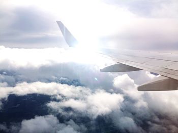 Cropped image of airplane flying over clouds