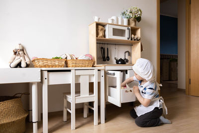 Side view of boy playing in kitchen