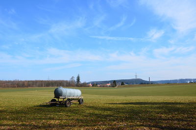 Horse cart on field against sky