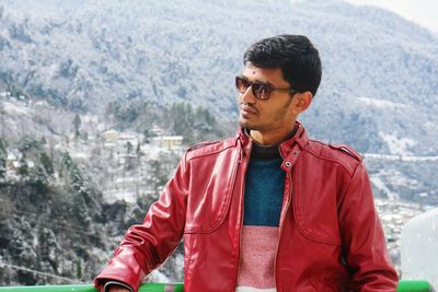 Young man wearing sunglasses standing on mountain