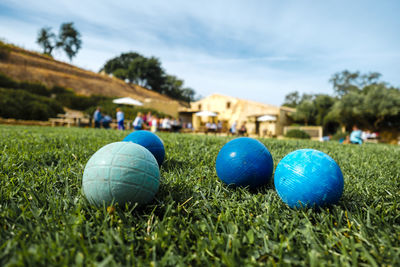 Close-up of multi colored ball on grass against blue sky