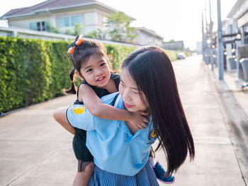 Portrait of smiling girl with arms raised