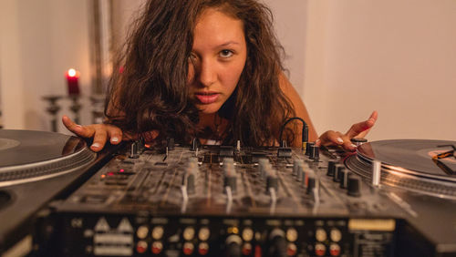 Close-up of fashionable young woman playing music at home