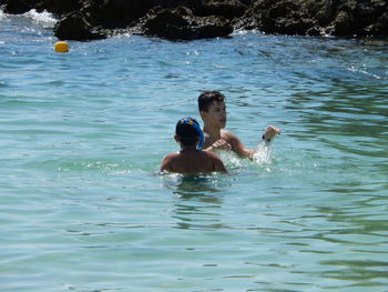 Full length of shirtless boy swimming in water