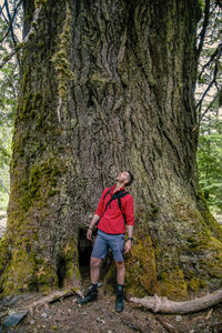 Man standing against tree in forest