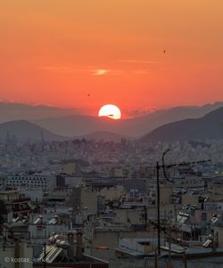 Aerial view of city against orange sky