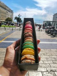 Close-up of hand holding food on street in city