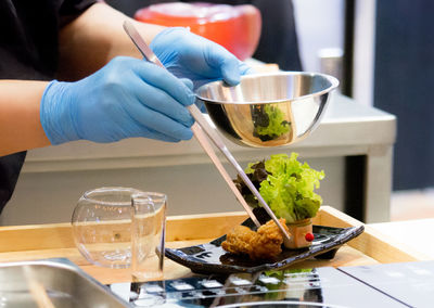 Cropped hand of person preparing food on table