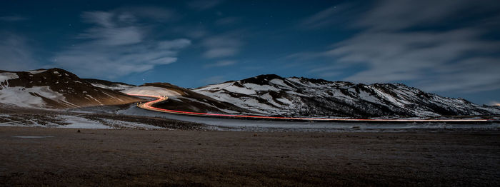 Scenic view of snowcapped mountains against sky at night