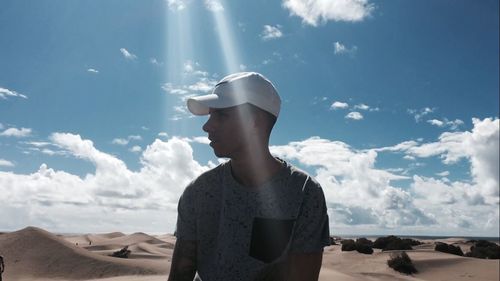 Thoughtful man at desert against sky